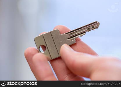 Holding a house key in the hand: New home and property.