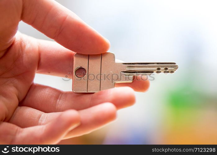 Holding a house key in the hand: New home and property.