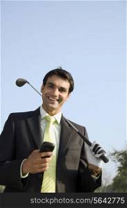Holding a phone and a golf club