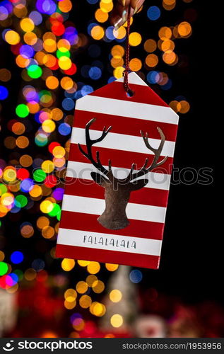 Holding Christmas decoration against bokeh lights background