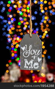 Holding Christmas decoration against bokeh lights background