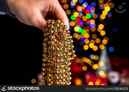 Holding Christmas decoration against bokeh lights background