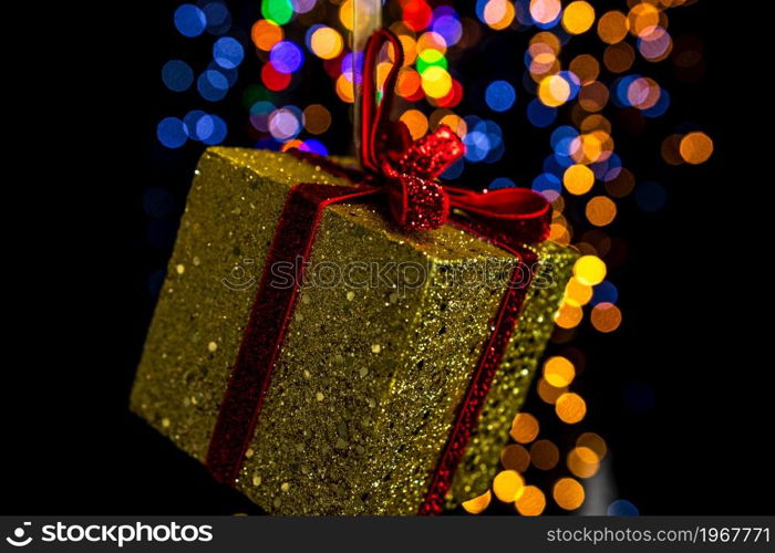 Holding Christmas decoration against bokeh lights background