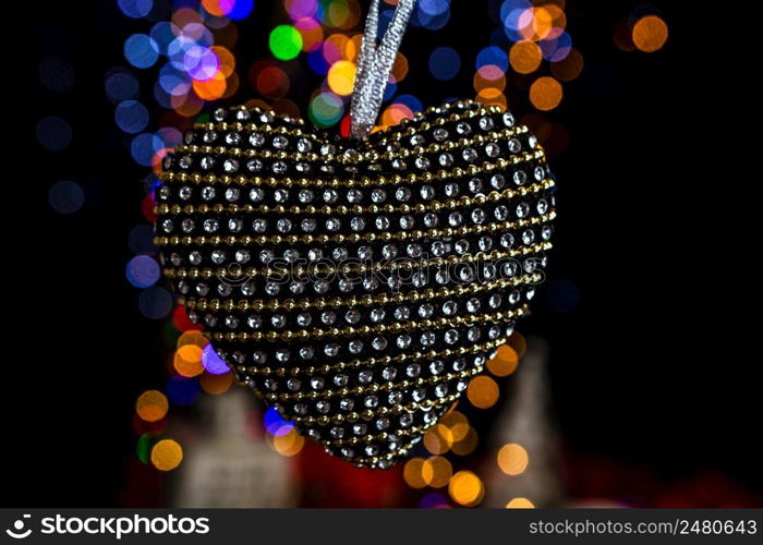 Holding Christmas decoration against bokeh lights background