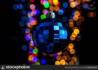 Holding Christmas decoration against bokeh lights background