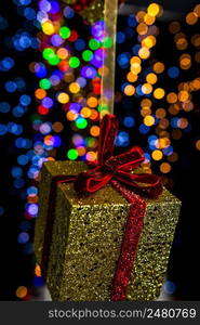 Holding Christmas decoration against bokeh lights background