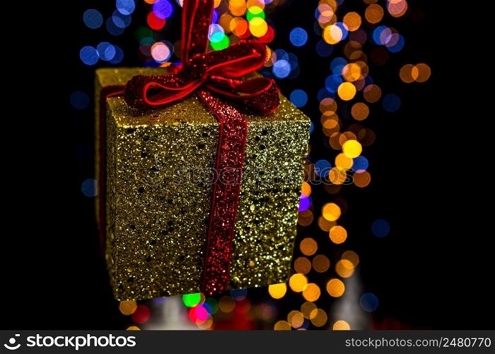 Holding Christmas decoration against bokeh lights background