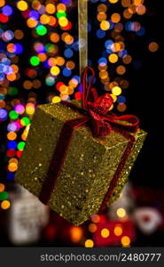 Holding Christmas decoration against bokeh lights background