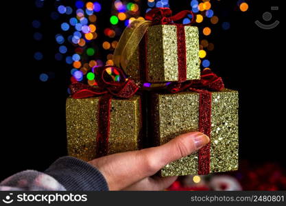 Holding Christmas decoration against bokeh lights background