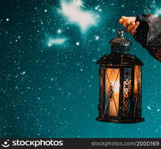 holding lantern on dark winter night