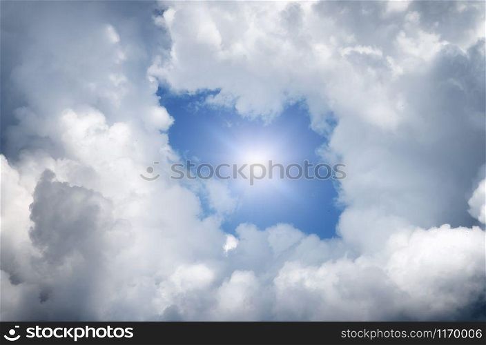 Hole in the clouds. Beautiful white clouds on blue sky with holes in the center.