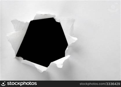 Hole in the white paper with torn sides