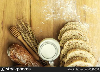 Hole wheat breads and fresh milk on table with free copy space for background.