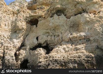 holes in rock near lagos algarve portugal looking like death face skull