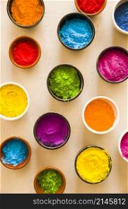 holi color powder inside different type bowls concrete backdrop