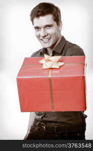 Holiday and special occasion. Young handsome man giving red present gift box with golden ribbon isolated on white. Surprise. Studio shot.