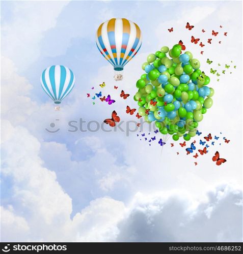 Holiday background. Sunny image with balloons and aerostat flying in blue sky