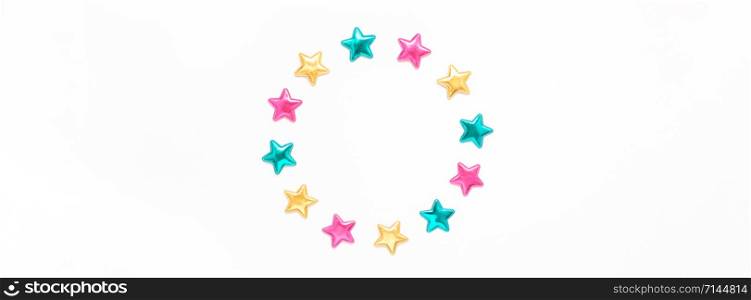 Holiday composition. New Year or Christmas pattern flat lay top view Xmas holiday celebration decorative color stars round wreath frame on white background with copy space. Template of greeting card