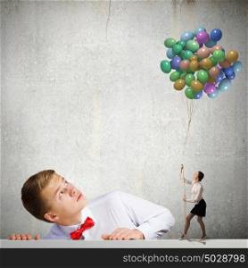 Holiday concept. Businessman looking at woman holding bunch of colorful balloons