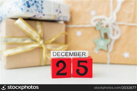 Holiday concept, close-up. December 25 is lined with red cubes along with the inscription December on the background of sealed gifts. Holiday concept, close-up. December 25 is lined with red cubes along with the inscription December on the background of sealed gifts.