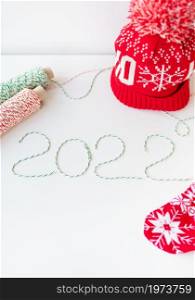 Holiday concept for Christmas and New Year 2022. Layout of various Christmas attributes - hat, sock, striped threads for packaging. Holiday concept for Christmas and New Year 2022. Layout of various Christmas attributes - hat, sock, striped threads for packaging.