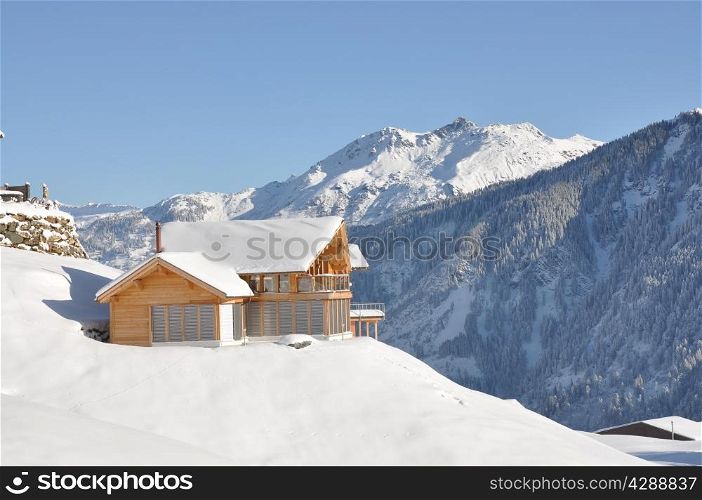 Holiday cottage against snowy Alps. Braunwald, Switzerland
