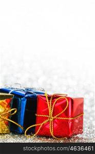 Holiday gifts in colorful boxes on silver bokeh background