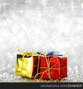 Holiday gifts over shiny glitter background with stars