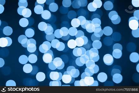 holiday illumination and background concept - christmas garland with classic blue lights bokeh. christmas background with classic blue lights