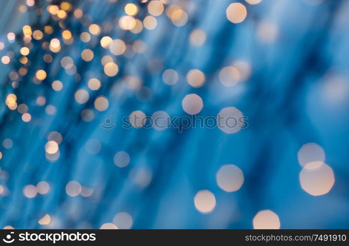 holiday, illumination and decoration concept - bokeh of christmas garland lights over dark blue background. christmas garland lights over dark blue background