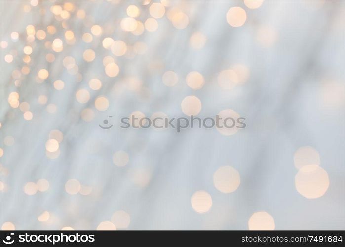 holiday, illumination and decoration concept - bokeh of christmas garland lights over grey background. christmas garland lights over grey background