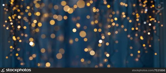 holiday illumination and decoration concept - christmas garland bokeh lights over dark blue background. christmas garland lights over dark blue background
