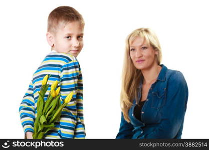 Holiday mother&#39;s day concept. Rear view little boy with bunch of yellow tulips behind back preparing nice surprise for his mother isolated on white