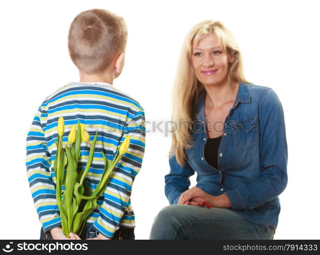 Holiday mother&#39;s day concept. Rear view little boy with bunch of yellow tulips behind back preparing nice surprise for his mother isolated on white