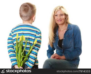 Holiday mother&#39;s day concept. Rear view little boy with bunch of yellow tulips behind back preparing nice surprise for his mother isolated on white