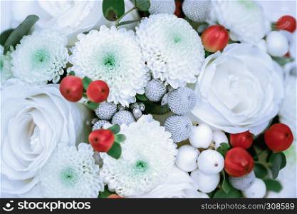 Holiday or wedding decoration - beautiful white flowers with red berries and green leaves. Selective focus, blurred.. White With Red Floral Background