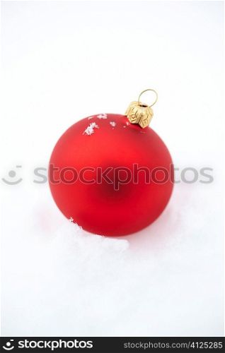 holiday photo with red ball on real snow background, selective focus