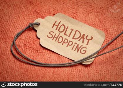 holiday shopping sign - a price tag with a string against textured handmade paper