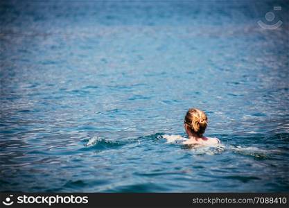 Holiday sports: Woman is swimming in the blue water