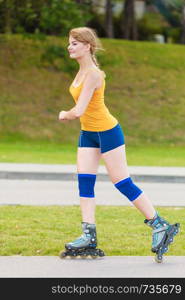 Holidays, active lifestyle freedom concept. Young fit woman on roller skates riding outdoors on street, girl rollerblading on sunny day