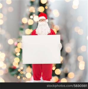 holidays, advertisement and people concept - man in costume of santa claus with white blank billboard over christmas tree lights background