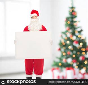 holidays, advertisement and people concept - man in costume of santa claus with white blank billboard over living room and christmas tree background