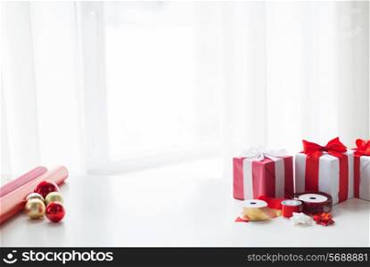 holidays and celebration concept - christmas presents, decoration paper, ribbons and scissors at home