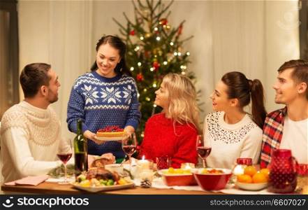holidays and celebration concept - happy friends having christmas dinner at home. happy friends having christmas dinner at home