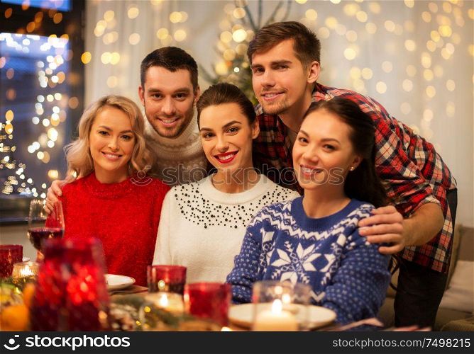 holidays and celebration concept - happy friends having christmas dinner at home. happy friends celebrating christmas at home