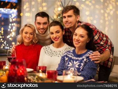 holidays and celebration concept - happy friends having christmas dinner at home. happy friends celebrating christmas at home