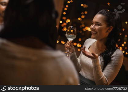 holidays and celebration concept - happy woman having christmas dinner at home and drinking white wine. happy woman drinking wine at christmas dinner