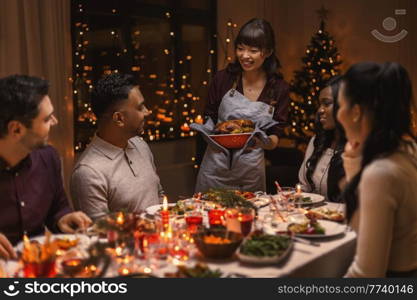 holidays and celebration concept - multiethnic group of happy friends having christmas dinner at home. happy friends having christmas dinner at home