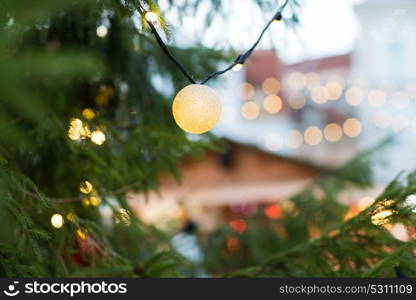 holidays and decoration concept - close up of christmas tree garland bulb outdoors. close up of christmas tree garland bulb outdoors