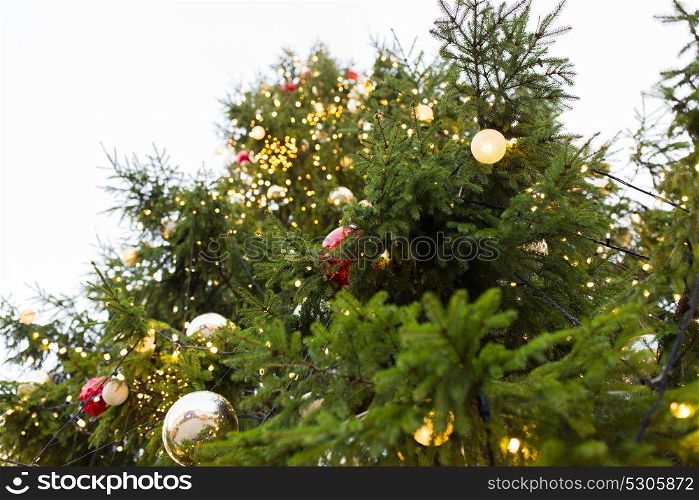 holidays and decoration concept - close up of natural fir with christmas tree toys outdoors. close up of fir with christmas tree toys outdoors
